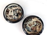 pair of ceramic plates with a painting of a man and a woman sitting on a bench