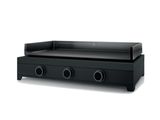 une grille noire surmontée de trois brûleurs