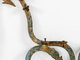 pair of metal sculptures of a dragon and a bird on wheels
