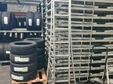 a large stack of tires sitting on top of pallets in a warehouse