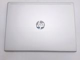 the back of a laptop computer sitting on top of a white table