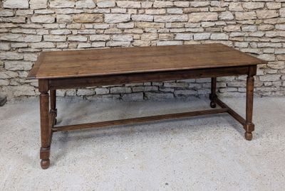 a wooden table sitting in front of a brick wall