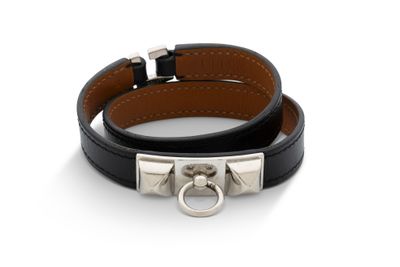 un gros plan sur un bracelet en cuir noir muni d'un fermoir en argent