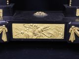 a black and gold clock with gold decorations on it