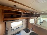 a view of the inside of a camper with a sink and a mirror