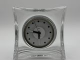 une horloge en verre posée sur une table