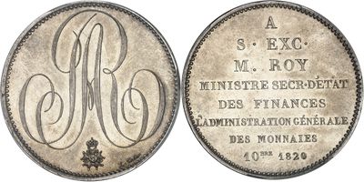 un gros plan d'une pièce de monnaie sur laquelle figure un monogramme
