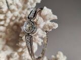 a close up of a ring on a coral with a diamond