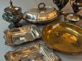 several silver trays and silverware are on a table
