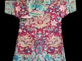 un gros plan sur un t-shirt rouge et bleu orné de fleurs et d'oiseaux