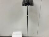 un lampadaire avec un abat-jour noir et une boîte blanche à côté