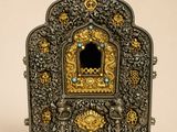 un coffret ouvragé en argent et en or, orné d'une petite fenêtre au milieu