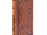 un livre en cuir marron dont la couverture est ornée d'un motif complexe