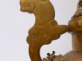a gold vase with a bird on top of it