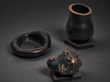trois pièces de poterie noire posées sur une table