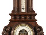 une horloge accrochée au mur, sur laquelle se trouve un baromètre