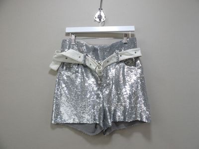 un short argenté à paillettes suspendu à un cintre contre un mur