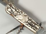 a knife that has been carved with a picture of an elephant