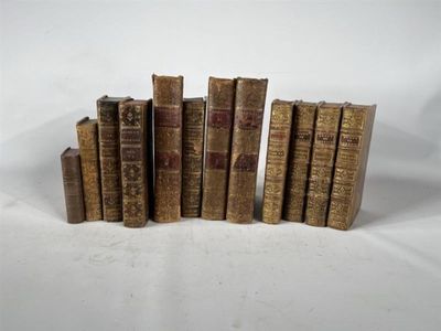 six vieux livres empilés les uns sur les autres sur une surface blanche