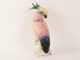 a figurine of a pink parrot on a white background