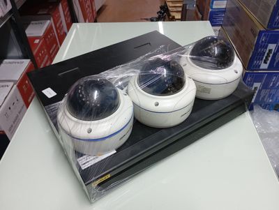 three cameras sitting on top of a table in a store