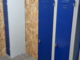 two blue lockers in a room with plywood walls