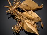 an image of a gold broochle with leaves and leaves attached to it