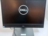 the dell monitor is sitting on top of the desk