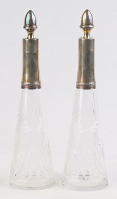 deux salières et poivrières en verre transparent posées sur une surface blanche
