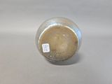 a small vase with a tag on it sitting on a table