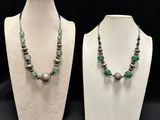 two necklaces and a bracelet on a mannequin stand