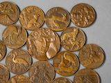 a close up of a pile of gold coins on a white surface