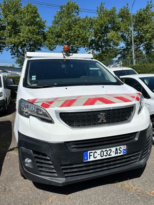 une camionnette blanche garée dans un parking avec d'autres voitures