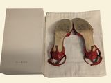they are two pairs of red shoes in a box on a white surface