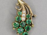 a close up of a green and white broochle on a white surface