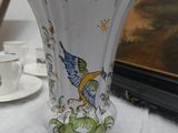 a vase with a bird on it sitting on a table