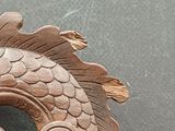 a wooden sculpture of a dragon on display on a table