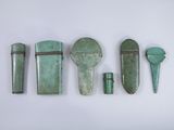 quatre pièces de métal vert sont disposées sur une surface blanche