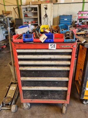 une boîte à outils rouge sur laquelle sont posés des outils, dans un garage