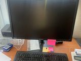 un écran d'ordinateur et un clavier posés sur un bureau, avec une calculatrice et une autre calculatrice