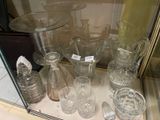 de nombreux vases et verres en verre exposés dans une vitrine