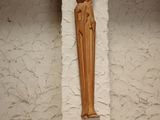 a wooden statue of a person on a shelf