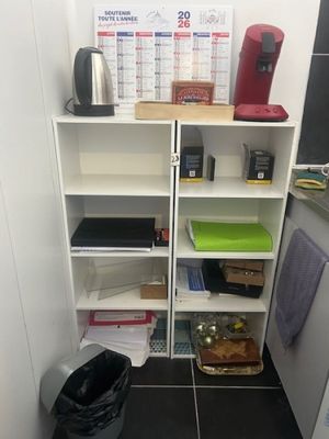 a kitchen with a black tile floor and a white bookcase