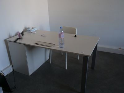 a white desk with a bottle of water on top of it
