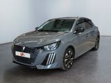 Une voiture grise est garée dans une pièce aux murs blancs.