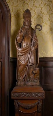 une statue représentant un homme tenant un bâton dans une pièce