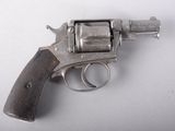 un pistolet posé sur une surface blanche