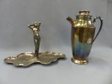 une théière en argent et une assiette en argent posées sur une table