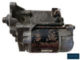 un gros plan d'un moteur sur fond blanc, présentant des traces de rouille