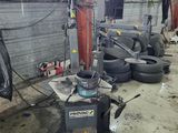 a machine that is sitting in a garage with some tires